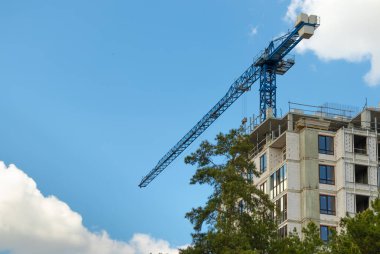 İnşaat vinci ve bulutlu mavi gökyüzüne karşı bir ev inşa etmek