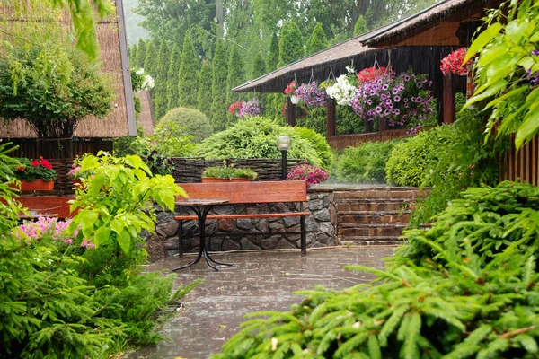 Deszcz Ogrodzie Podwórkowym Kwiatami Stołem Ławką Letni Dzień — Zdjęcie stockowe