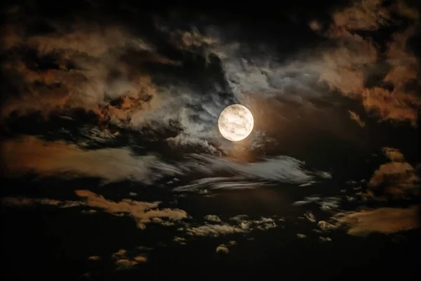 満月は暗い夜空に劇的な色の雲に囲まれています 望遠レンズを通して撮影したHdr写真 — ストック写真