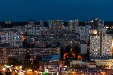 Kyiv şehri, Ukrayna - 9 Ekim 2022: Çok katlı çok katlı binalarla yoğun kentsel gelişim. Evlerin pencerelerinde ışık olan akşam manzarası