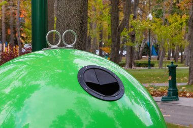 Şehir parkındaki modern büyük yeşil çöp tenekesi. Çöp ayıklama kavramı