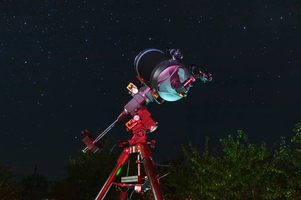 Modern astronomical telescope is aimed at the stars in the sky. Observing the sky through a telescope outdoors. The optical device is ready to study space objects
