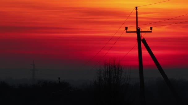 农村地区混凝土杆上有高压电的红色落日落日 — 图库视频影像