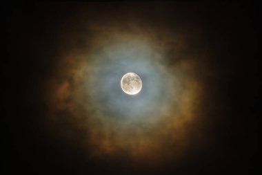 Gece karanlığında Ay renkli bulutlarla çevrilidir. Corona, küçük su damlacıkları ve bazen bir bulutun küçük buz kristalleri tarafından ay ışığının kırılması sonucu oluşan hafif optik fenomen.