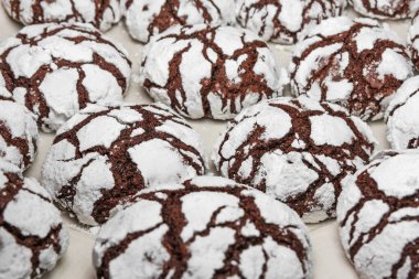 Üzerine pudra şekeri serpiştirilmiş ev yapımı kurabiyeler. Beyaz arka planda taze çikolatalı kurabiyeler.