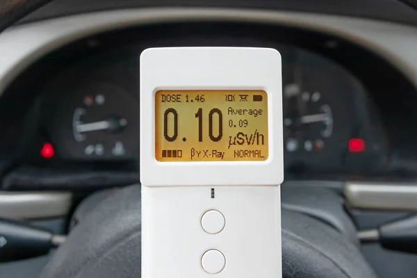 Measuring ionizing radiation in a car using a modern digital radiometer dosimeter device. Radiation safety control