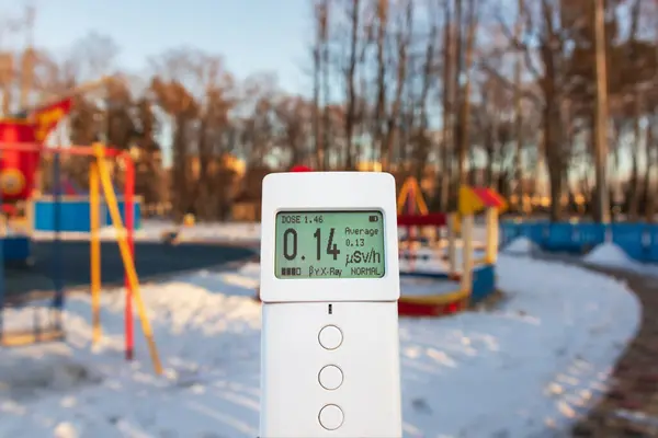 Measuring radiation using a modern dosimeter radiometer. Monitoring dangerous ionizing radiation outdoors in a city park or playground. Radiation safety control