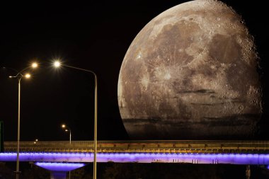 Süper Ay ufuktan yükseliyor. Gece vakti sokak ışıklarıyla yol köprüsünün üzerinde kocaman bir ayın kolajı.