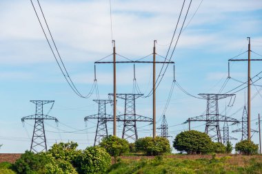 Elektrik iletimi. Metal ve beton destekli yüksek voltajlı elektrik hatları. Kentsel olmayan sanayi manzarası