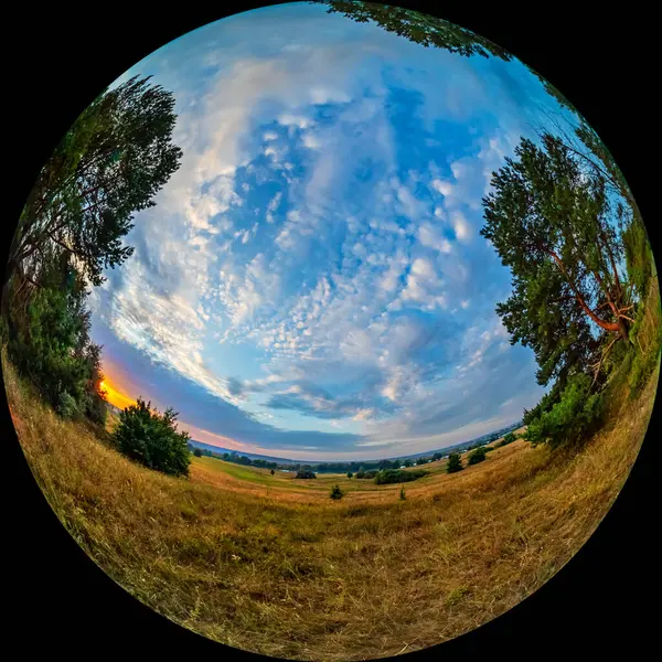 stock image Round photo with a view of the river valley at dawn. Wide-angle view shot through a circular fisheye lens. Non-urban landscape with meadow and pine trees, clouds in the sky. Summer morning