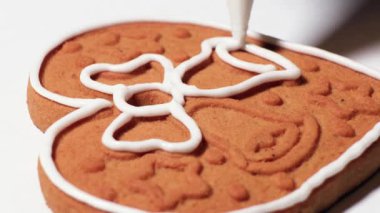 Cookies or gingerbread are covered and decorated with white sugar icing from a pastry bag