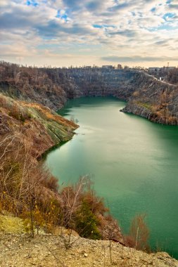 Ukrayna 'daki maden kaynakları. Terk edilmiş büyük bir granit ocağında yeşil bir göl. Maden ocağının manzarası suyla doldu.