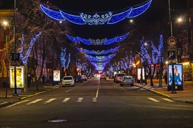 Kremenchuk şehri, Ukrayna - 9 Ocak 2025: Kremenchuk şehrinin ana caddesi yeni yıl ve Noel tatilleri için çelenkler ve ışık tesisleriyle süslenmiştir. Ağaçlarda parlayan ışıklar