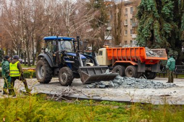 Kremenchuk şehri, Ukrayna - 21 Kasım 2022: Bir traktör, anıttan gelen beton enkazı ve taşları bir kamyona yükledi. Puşkin Anıtı 'nın yıkılması