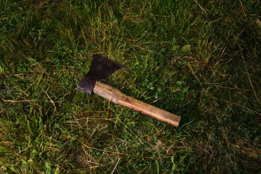 Akşamları ya da gece yeşil çimlerin üzerinde yaşlı bir balta yatar. Keskin tehlikeli balta - korku teması