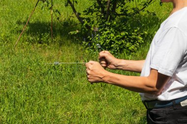 Ellerinde metal L şeklinde çubuklar olan bir musluk modern bir yatıştırıcı aleti. Radyasyon Uygulamaları - bilim tarafından kanıtlanmamış eski bir yöntem