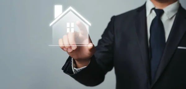 stock image Businessman pointing at house icon A real estate investment brokerage agent for buying selling as well as renting, providing financial investment advice on residences that suit family and client needs