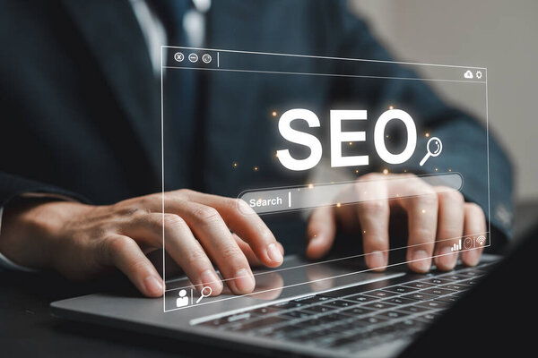 Заинтересованный бизнесмен использует ноутбук для улучшения стратегии SEO. Изображение запечатлевает современный цифровой маркетинг и онлайн-поиск в профессиональной среде.