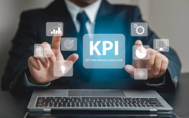 Bir işadamı, modern ofis ortamında veri analizi ve stratejik planlamayı gösteren bir dizüstü bilgisayardaki dijital anahtar performans göstergeleriyle etkileşim halindedir..