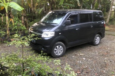 Kebumen, Central Java, Endonezya-01 Şubat 2022: Siyah Suzuki APV avlu yakınındaki yolda park halinde