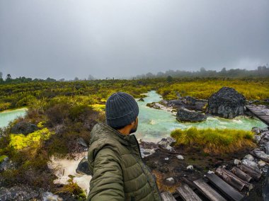 Purace, Cauca, Kolombiya 'daki San Juan kaplıcalarının manzarası, bulutlu bir gökyüzü altında canlı termal sular ve yemyeşil bir hava..