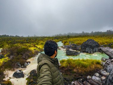 Purace, Cauca 'daki San Juan kaplıcalarının manzarası bulutlu bir gökyüzünün altında yemyeşil ve jeotermal suları sergiliyor..