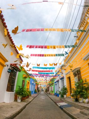 Kolombiya, Cartagena 'da canlı bir cadde, renkli dekorasyon ve kelebek motifleriyle süslenmiş, yerel kültür ve turizmin ruhunu yansıtıyor.