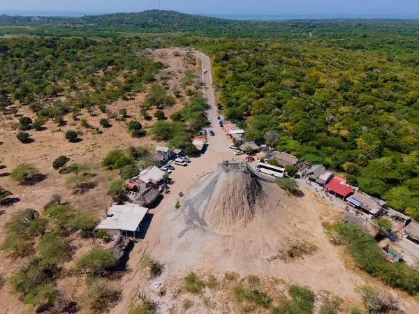 Kartagena 'daki Totumo Volkanı' nın göz kamaştırıcı hava manzarası, yemyeşil ve yerel yol kenarı tezgahlarıyla çevrili, eşsiz bir eko-turizm merkezi.