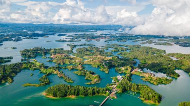 Guatape Gölü adalarının çarpıcı hava görüntüleri, canlı yeşillikler ve Kolombiya, Antioquia 'daki sakin sular sergileniyor.