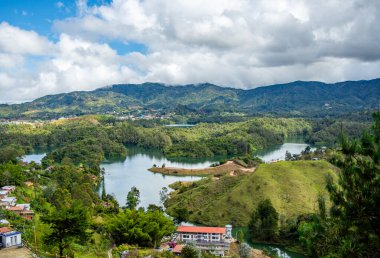 Guatape, Antioquia 'nın nefes kesici manzarası, yemyeşil göller ve yuvarlanan tepeler güzel bulutlu bir gökyüzü altında