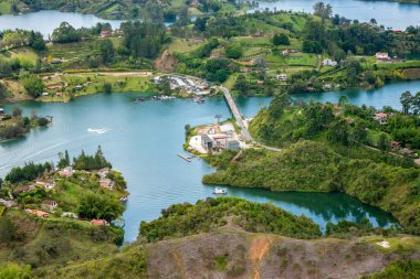 Guatape 'in çarpıcı hava manzarası, turkuaz suların, yemyeşil tepelerin ve Peol Stone' un etrafındaki canlı toplulukların görüntüsü. Kolombiya turizmi için mükemmel.