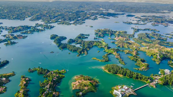 Antioquia, Kolombiya 'daki Guatape Rezervuarı' nın çarpıcı hava görüntüsü, sergilenen adalar, yemyeşil alanlar ve berrak mavi sular, turizm ve tatil için mükemmel.