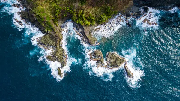 Sapzurro, Choco, Kolombiya 'da turkuaz okyanus dalgalarıyla karşılaşan kayalık sahil şeridinin çarpıcı hava manzarası doğanın güzelliğini ve dinginliğini gözler önüne seriyor.