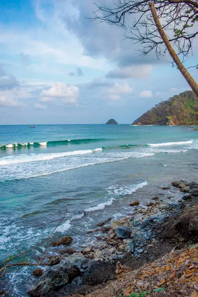 Çarpıcı Sapzurro, Choco, Kolombiya kıyı manzarası yumuşak dalgalar, kayalık kıyılar ve çarpıcı bir gökyüzü altında yemyeşil.