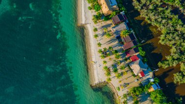 Rincon del Mar, Sucre 'deki çarpıcı sahil manzarası, palmiye ağaçları, kumlu plajlar ve canlı yerel mimari.