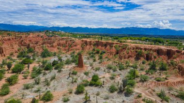 Huila 'daki Tatacoa Çölü' nün havadan görünüşü açık mavi gökyüzüne karşı eşsiz kaya oluşumları ve yemyeşil bitki örtüsü sergiliyor.