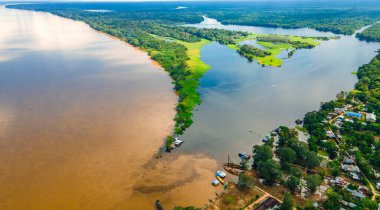 Leticia, Kolombiya 'daki Amazon Nehri' nin havadan görünüşü, gösterişli tekneler ve verimli tropikal ormanlar, biyolojik çeşitliliği ve doğal güzelliği vurguluyor..