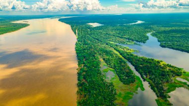 Leticia, Kolombiya 'daki Amazon Nehri' nin havadan görünüşü, gösterişli tekneler ve verimli tropikal ormanlar, biyolojik çeşitliliği ve doğal güzelliği vurguluyor..