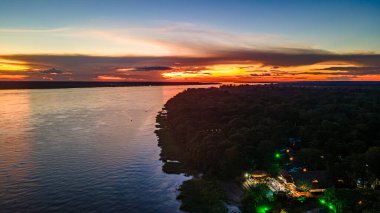 Leticia, Kolombiya 'da Amazon Nehri üzerinde sakin suları ve canlı gökyüzünü gösteren sakin bir günbatımı, doğa severler ve seyahat meraklıları için mükemmel..