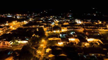 Geceleri Kolombiya, Guatavita 'nın çarpıcı hava manzarası, aydınlatılmış binalar ve arka planda manzaralı Laguna de Guatavita.