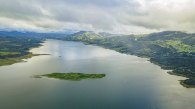 Guatavita Gölü 'nün yukarısındaki yıldızlı gökyüzünün nefes kesici görüntüsü, Samanyolu' nun ve suyun üzerindeki huzurlu yansımalarının yer alması, doğanın güzelliğini gözler önüne seriyor..
