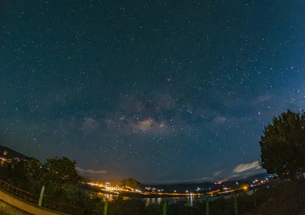 Guatavita Gölü 'nün yukarısındaki yıldızlı gökyüzünün nefes kesici görüntüsü, Samanyolu' nun ve suyun üzerindeki huzurlu yansımalarının yer alması, doğanın güzelliğini gözler önüne seriyor..