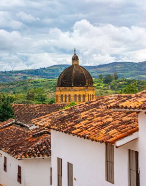 Geleneksel çatılara ve bulutlu gökyüzünün altında tarihi bir kubbeye sahip Barichara 'nın güzel manzarası.