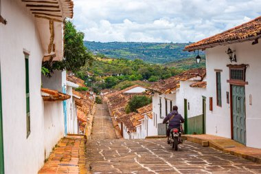 Geleneksel çatılara ve bulutlu gökyüzünün altında tarihi bir kubbeye sahip Barichara 'nın güzel manzarası.