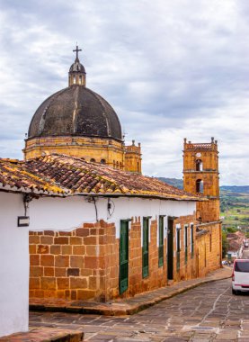Geleneksel çatılara ve bulutlu gökyüzünün altında tarihi bir kubbeye sahip Barichara 'nın güzel manzarası.