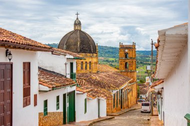 Geleneksel çatılara ve bulutlu gökyüzünün altında tarihi bir kubbeye sahip Barichara 'nın güzel manzarası.