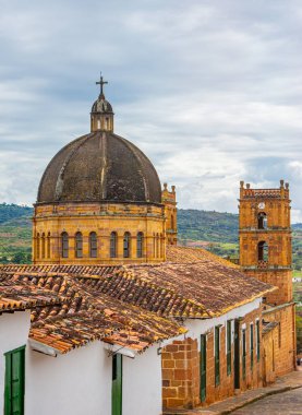 Geleneksel çatılara ve bulutlu gökyüzünün altında tarihi bir kubbeye sahip Barichara 'nın güzel manzarası.