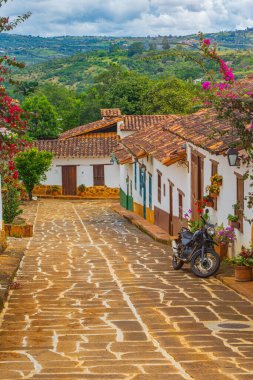 Geleneksel çatılara ve bulutlu gökyüzünün altında tarihi bir kubbeye sahip Barichara 'nın güzel manzarası.