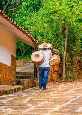 Barichara, Kolombiya 'nın büyüleyici caddeleri, geleneksel mimarinin ve yerli halkın canlı kıyafetlerinin sergilendiği. Turizm ve tatil görüntüleri için mükemmel..