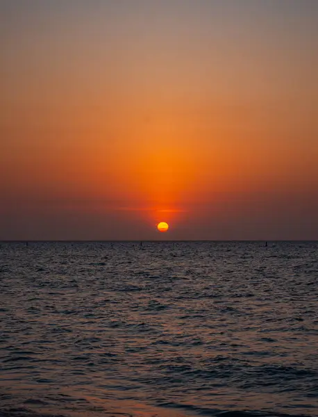 Playa Blanca, Cartagena, Kolombiya 'da el ele yürüyen bir çiftin romantik günbatımı sahnesi. Tatil ve turizm için mükemmel..